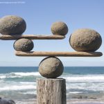 rocks-balancing-on-driftwood–sea-in-background-153081592-591bbc3f5f9b58f4c0b7bb16